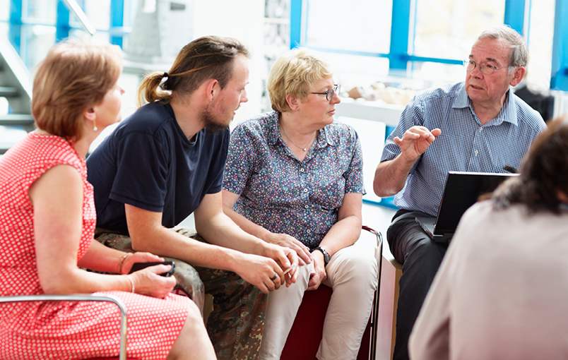A small group of people from the community engaged in a discussion in the local libaray